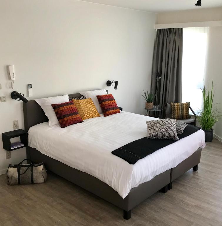 Un dormitorio con una cama grande con almohadas de colores. en CITYSTAY, en Amberes