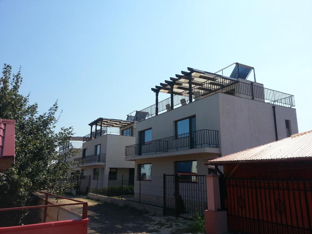 a white building with balconies on top of it at Vila Verda in Eforie Nord