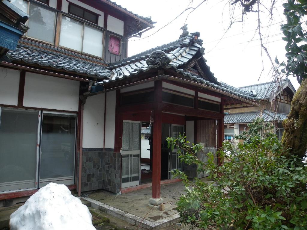 an asian house with a roof at 田舎生活体験福井県観光者向け古民家 in Sabae