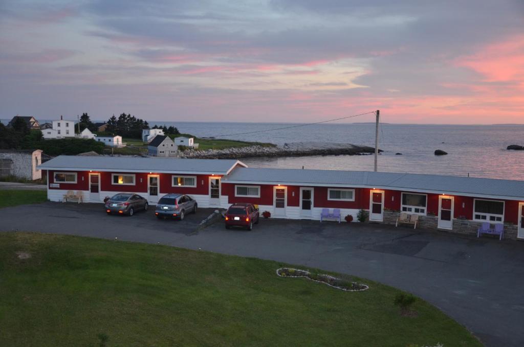 a building with cars parked in a parking lot at Clifty Cove Motel in Peggy's Cove