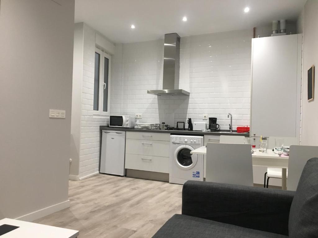 レオンにあるAPARTAMENTOS GyC VIVIENDAS DELUXEの白いキッチン(洗濯機、コンロ付)