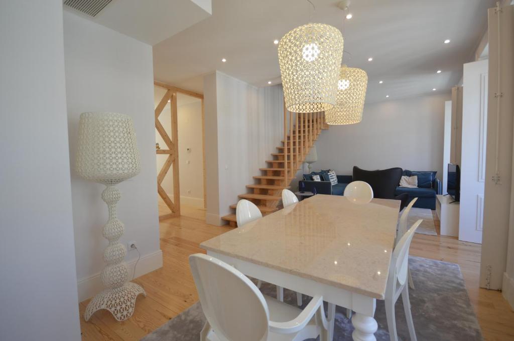 a dining room and living room with a table and chairs at Silver Side River in Lisbon