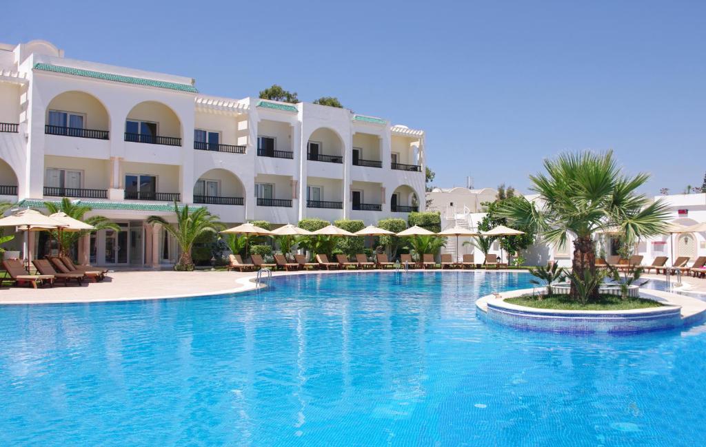 a large swimming pool in front of a hotel at Royal Nozha in Hammamet