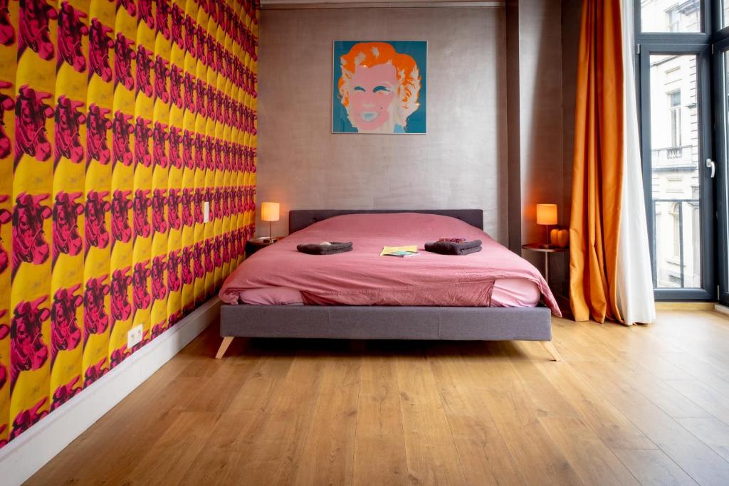 a bedroom with a bed with a colorful wall at Quartier Leonard in Ghent