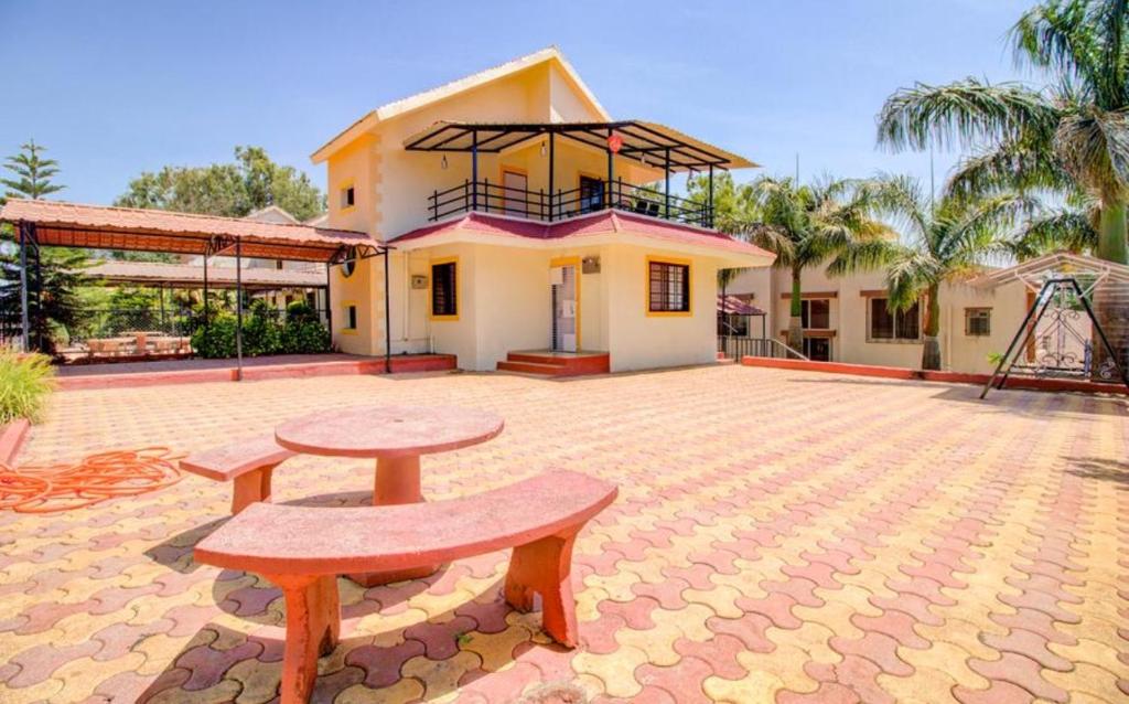 a house with a bench in front of it at West Valley Villa in Panchgani
