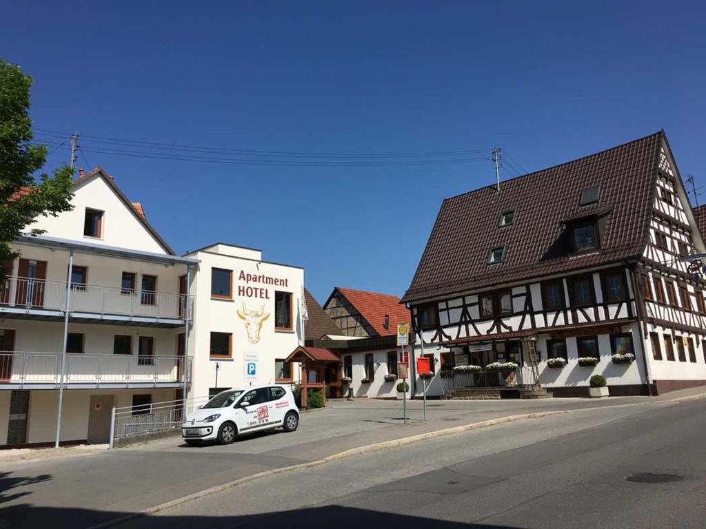 einem kleinen weißen Auto, das vor einem Gebäude parkt in der Unterkunft Gasthof zum Ochsen in Mössingen