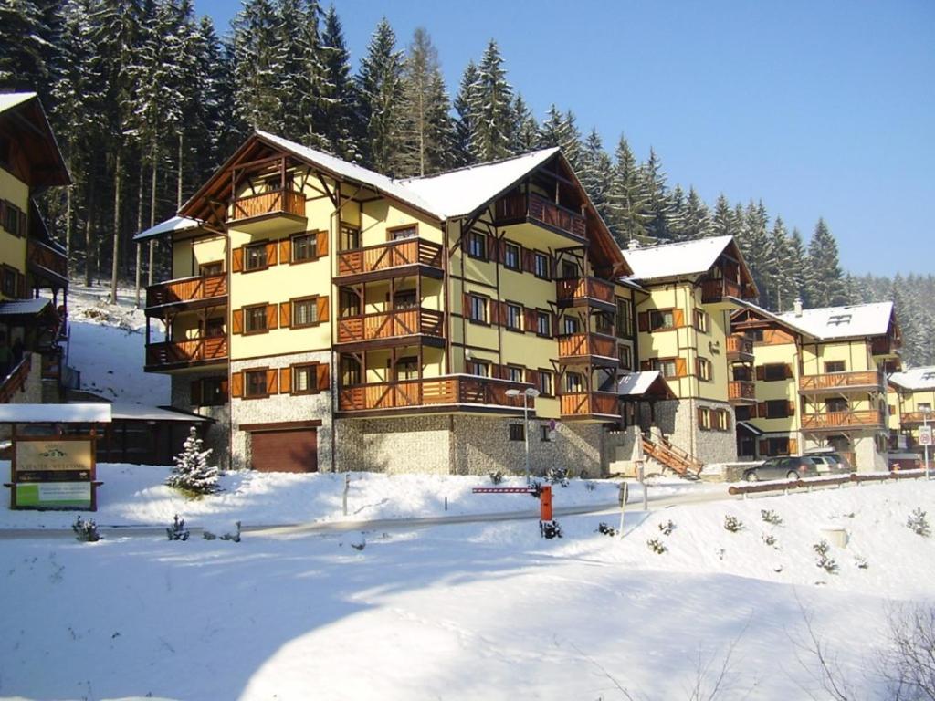 un gran edificio de apartamentos con árboles en la nieve en Apartmán Renáta 10 en Ružomberok