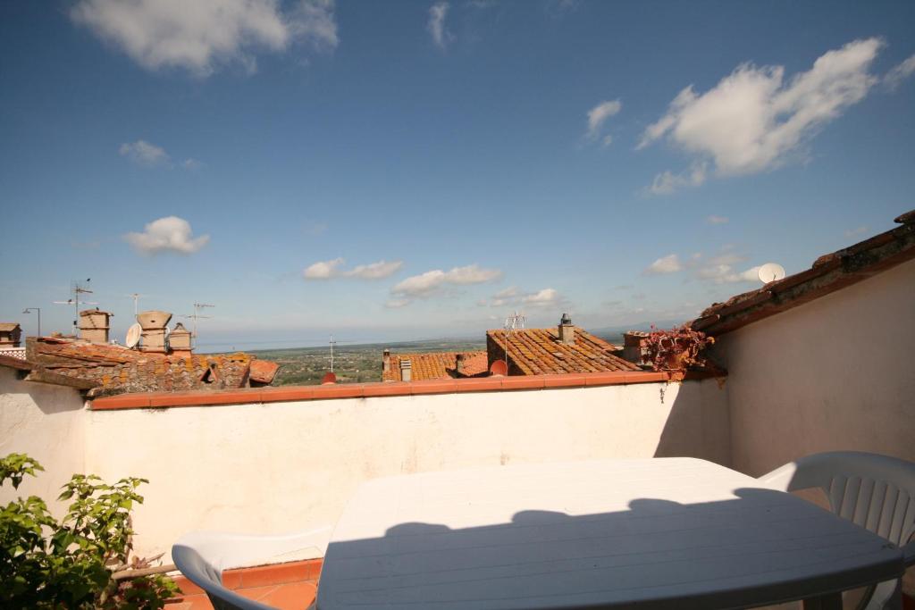 un tavolo e sedie su un balcone con vista di Terrazza e Vista Mare a Castagneto Carducci