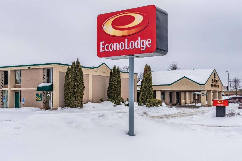 um sinal na neve em frente a uma loja em Econo Lodge em Brainerd