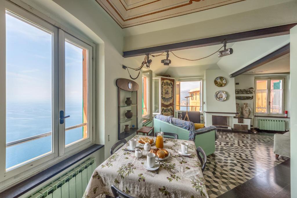 jadalnia ze stołem i dużymi oknami w obiekcie CASA CONSTANZA Pace e Relax in Liguria w mieście Camogli
