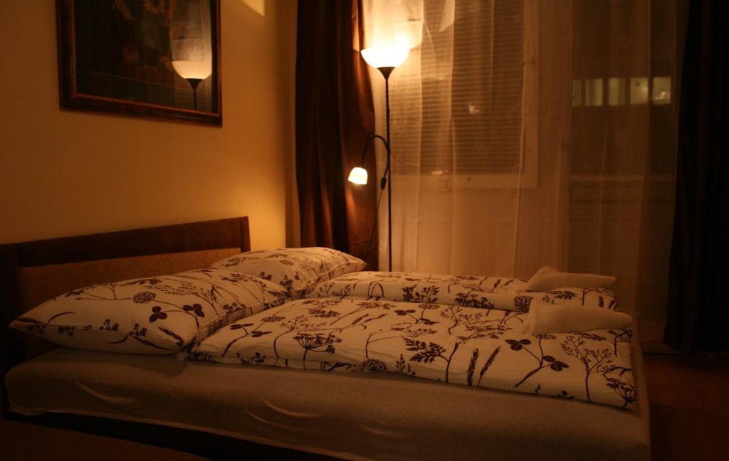 1 dormitorio con cama con edredón y ventana en Margaret Bridge Studio Apartment, en Budapest