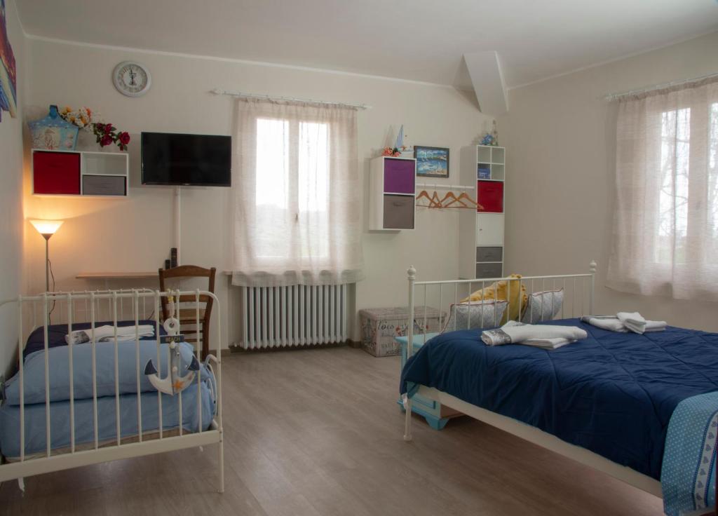 a bedroom with two beds and a tv on the wall at La Luna nel Parco in Fano