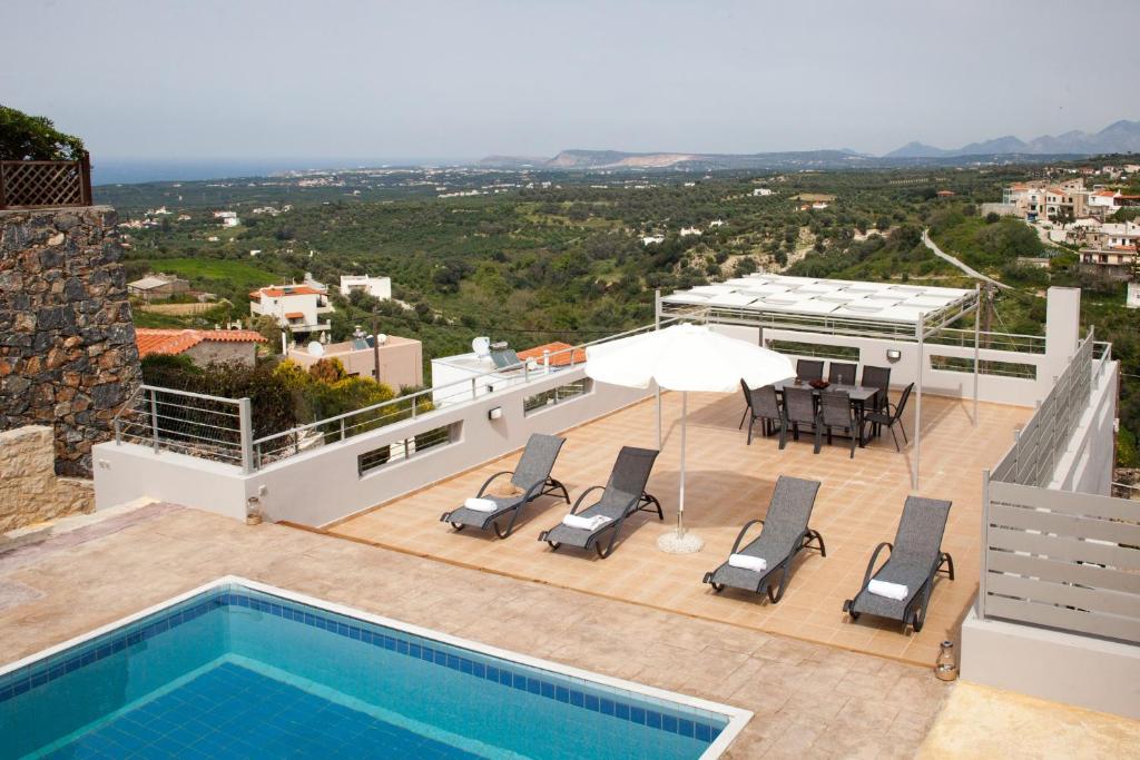 a villa with a swimming pool on top of a building at Villa Belair in Agia Triada