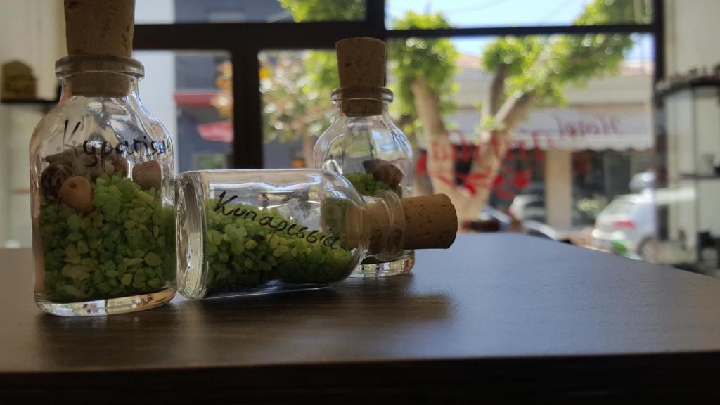 キパリシアにあるHotel Trifyliaの緑のぶどうをテーブルに並べたガラス瓶2本