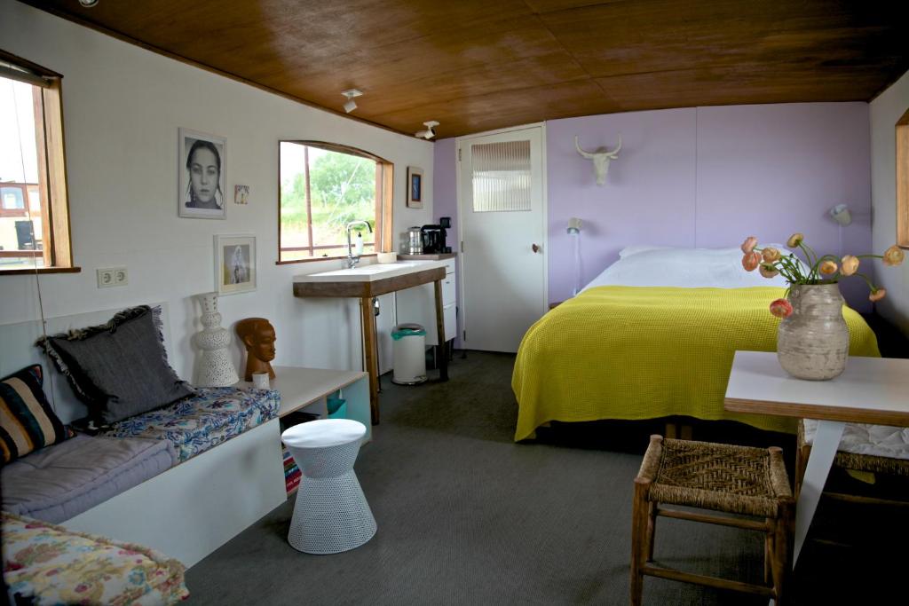 a bedroom with a bed and a sink in it at Bed in Boat Amsterdam in Amsterdam