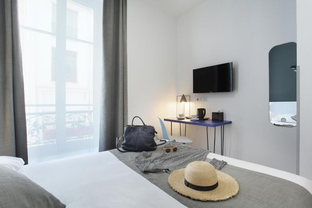 a hotel room with a bed with a hat on it at Hôtel Alcôve Nice in Nice