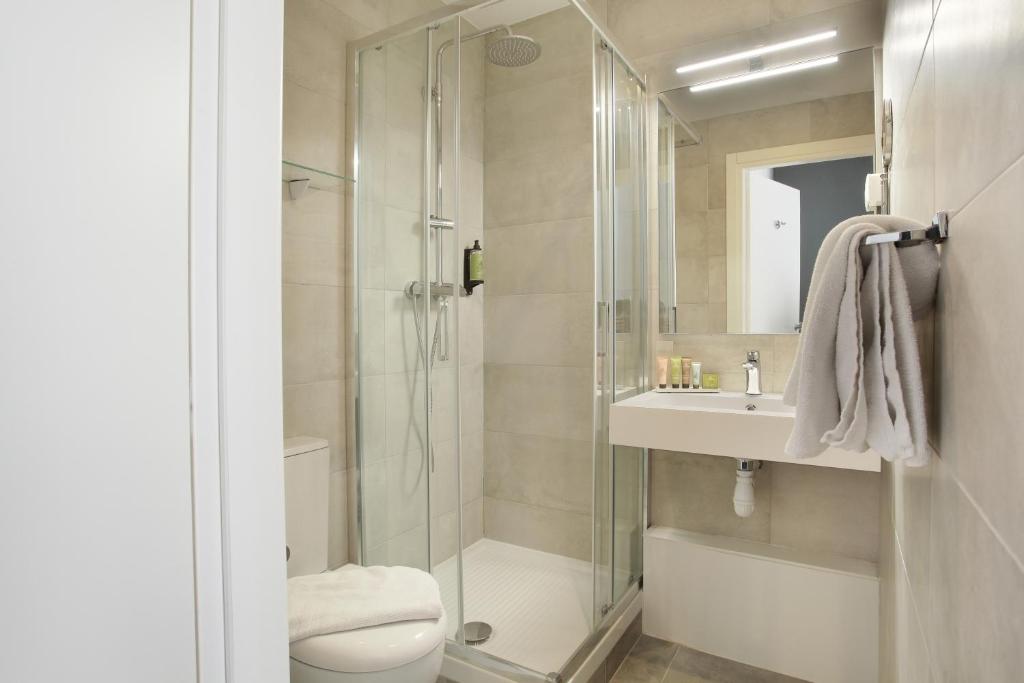 a bathroom with a shower and a toilet and a sink at Hôtel Alcôve Nice in Nice