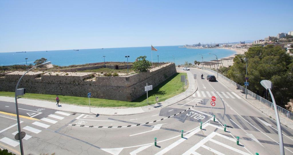 an empty street next to a wall with the ocean at Villa hortencia in Tarragona