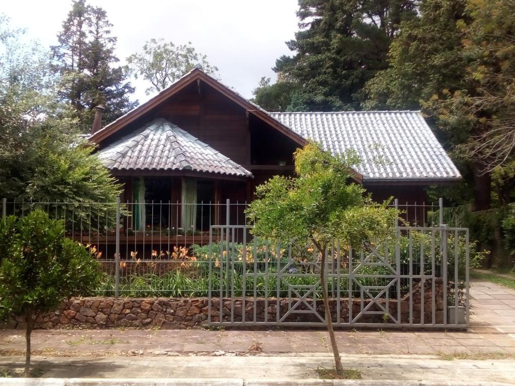 a house with a fence in front of it at Chalé Martinho in Gramado