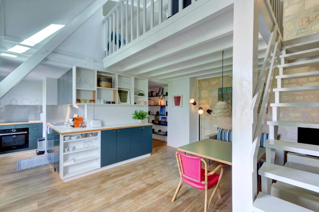 une cuisine et une salle à manger avec des armoires bleues et un escalier dans l'établissement L'Etoilé, à Bordeaux