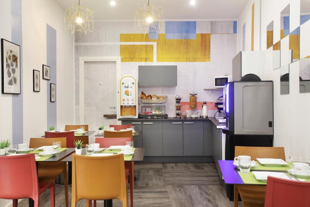a kitchen and dining room with tables and chairs at Hôtel Alcôve Nice in Nice