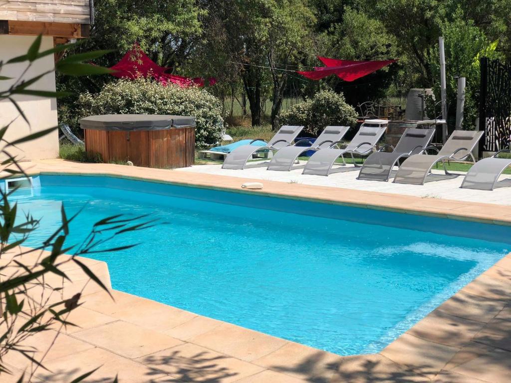 a swimming pool with lounge chairs and a swimming pool at Esprit d'Ailleurs in Baillargues