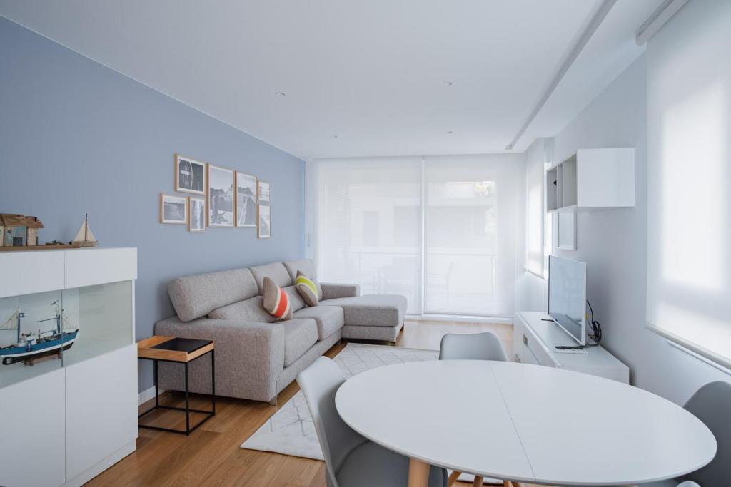 GOXUE HOME في سان سيباستيان: غرفة معيشة بيضاء مع أريكة وطاولة