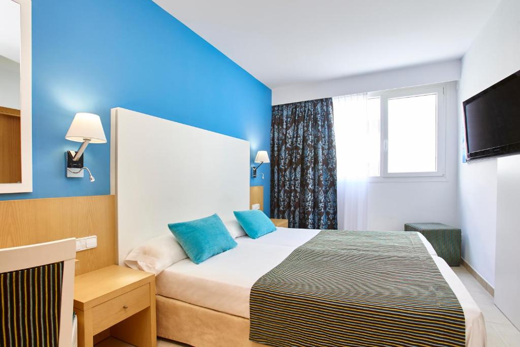 a hotel room with a bed and a television at Universal Hotel Marqués in Colònia de Sant Jordi