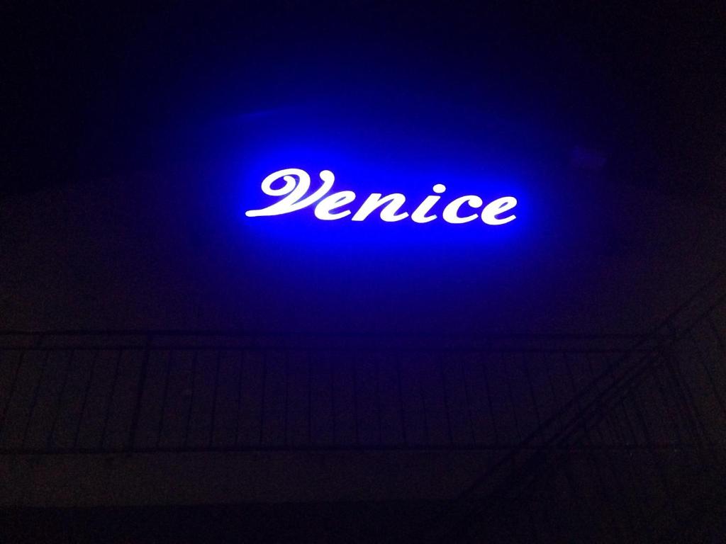 ゴルビツカヤにあるВенецияの青いネオンの看板