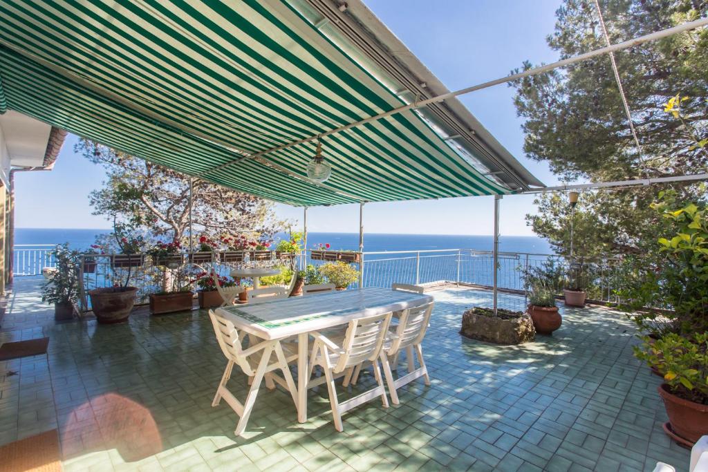 a table and chairs on a patio with the ocean in the background at Stunning View- Wifi & Parking in Villa Solari