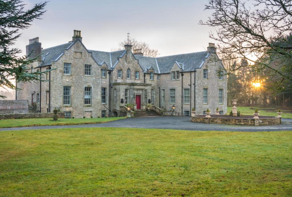 een oud stenen huis met een grote tuin bij Blanerne House in Duns