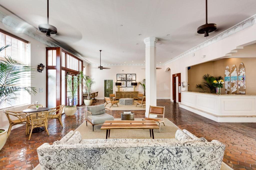 a living room with couches and tables and chairs at Clinton Hotel South Beach in Miami Beach