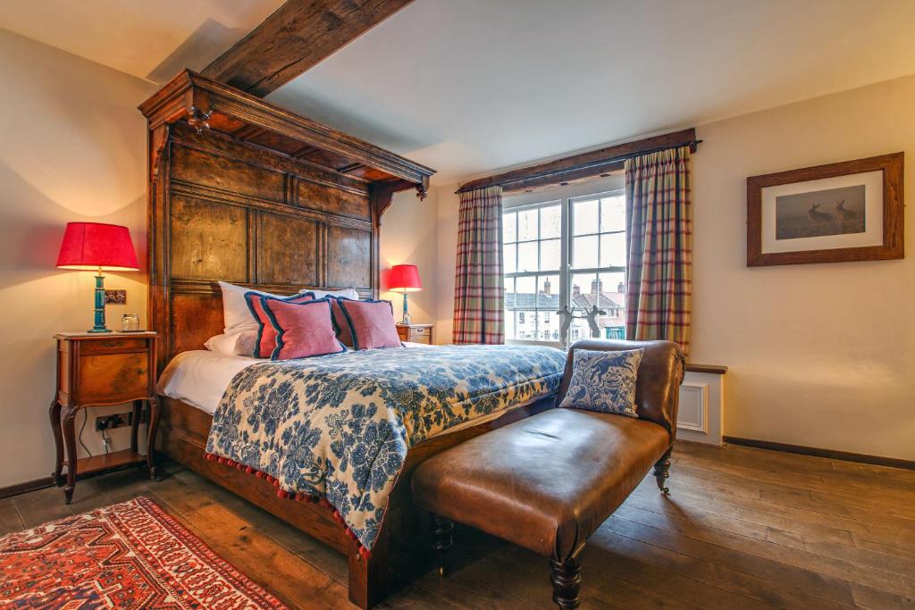 a bedroom with a bed and a chair and a window at Byfords in Holt