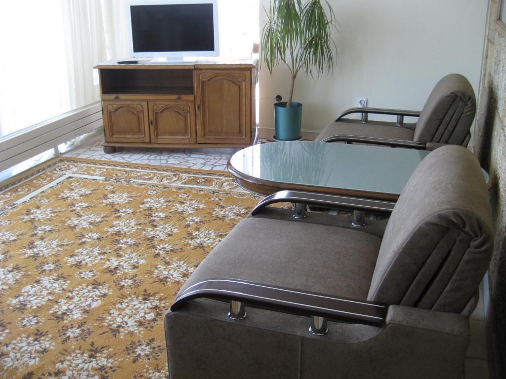 un soggiorno con 2 sedie, un tavolo e una TV di V3 Villa a Eforie Nord