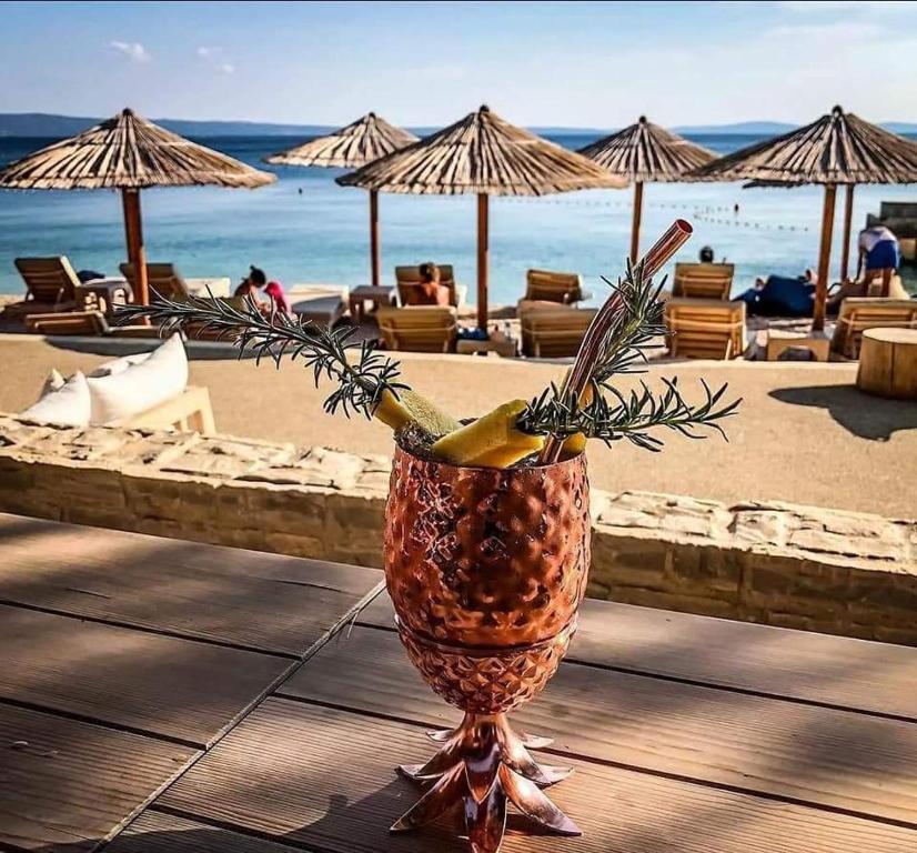 a pineapple vase sitting on a table next to a beach at Apartment Golden Dreams in Podstrana