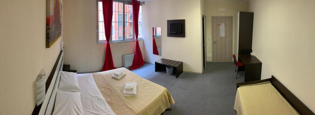 Habitación con 2 camas y pasillo con cortinas rojas. en Hotel Lucania, en Milán
