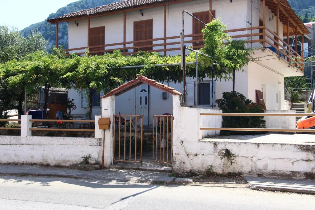 een huis met een hek ervoor bij Nona's Guest House Corfu Βenitses in Benitses