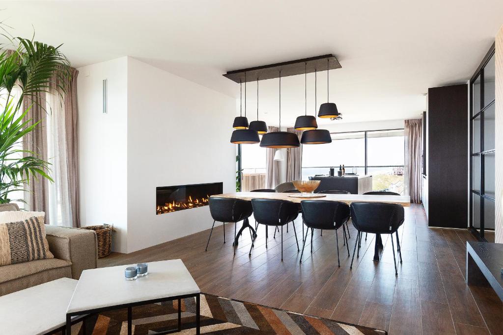 a living room with a dining room table and chairs at Maris Apartments in Egmond aan Zee