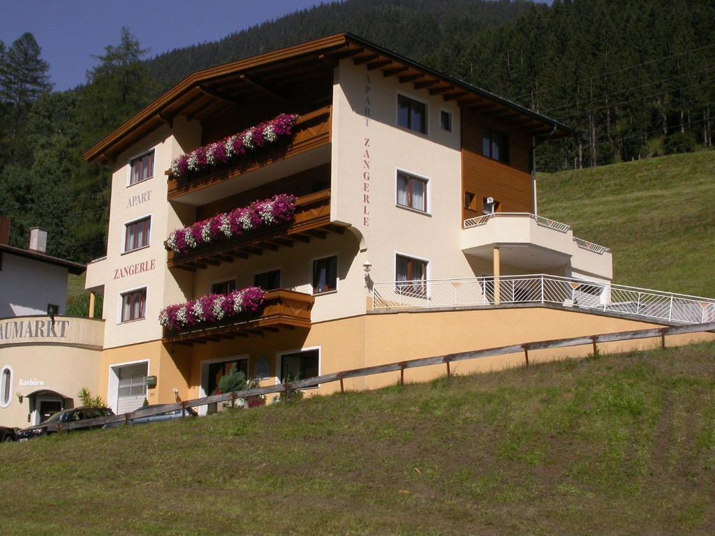 a building on a hill with flowers on it at Apart Zangerle in Kappl