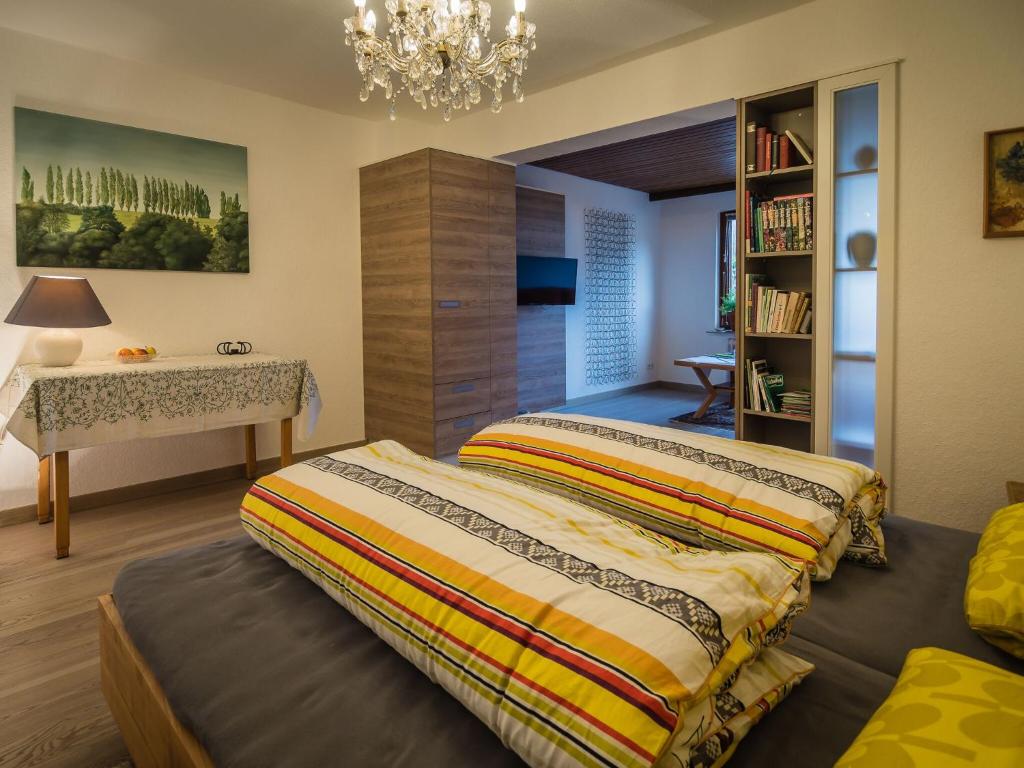 1 Schlafzimmer mit 2 Betten, einem Schreibtisch und einem Kronleuchter in der Unterkunft Antel 42 in Andernach