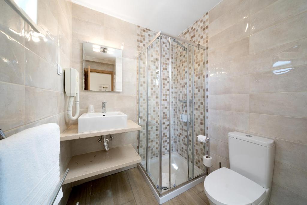 a bathroom with a toilet and a sink and a shower at Quinta das Andorinhas in Carvoeiro