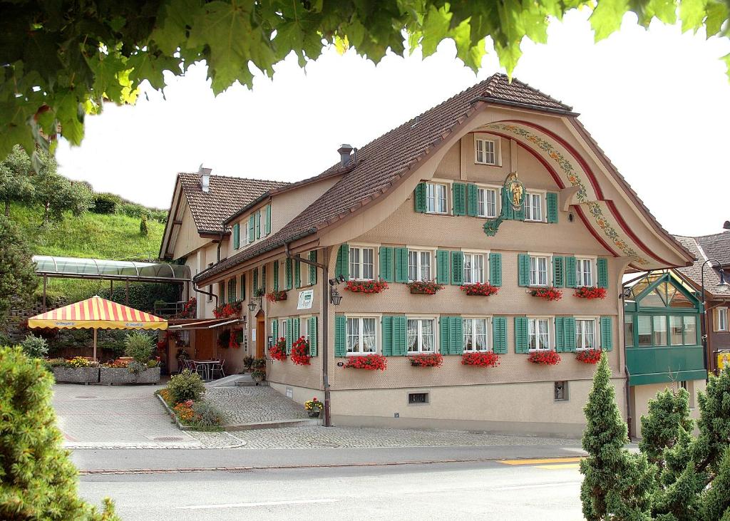 a building with green shutters and flowers on it at Gasthaus Engel Hasle in Hasle