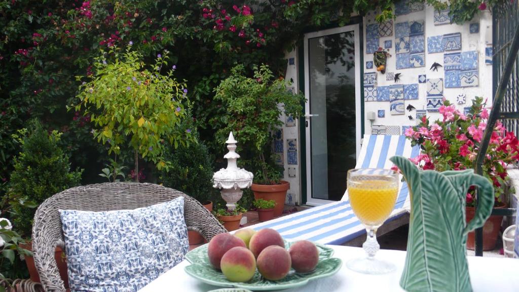un tavolo con un piatto di frutta e un bicchiere di succo d'arancia di Oliveirinha a Lisbona