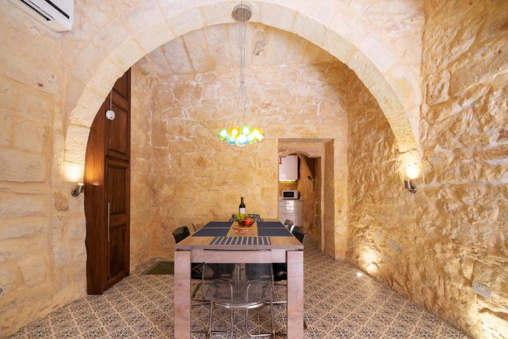 16 lettings - charming character house في بيرغو: غرفة طعام مع طاولة في جدار حجري