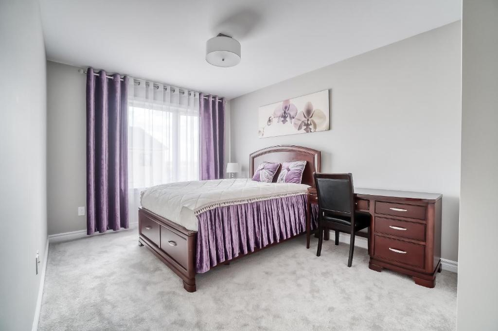 a bedroom with a bed and a desk and a window at Henia's INN in Ottawa