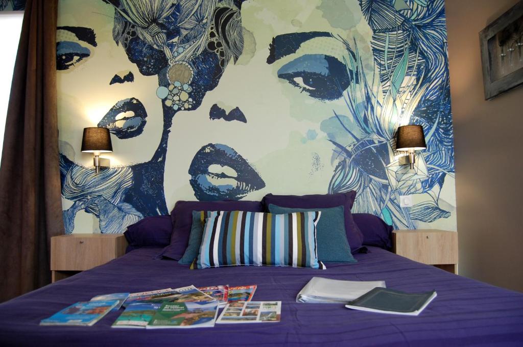 a bedroom with a purple bed with a face on the wall at Le Clos des Barelles in Six-Fours-les-Plages