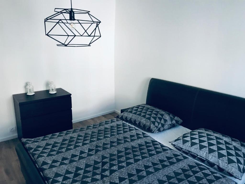 a bedroom with a bed and a black lamp at Príkopova 2 Apartmán in Bratislava