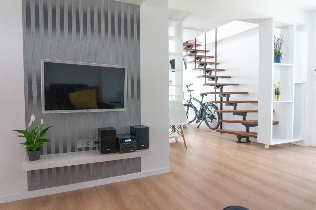 a living room with a television and a staircase at Apartman Zagreb Maksimir in Zagreb