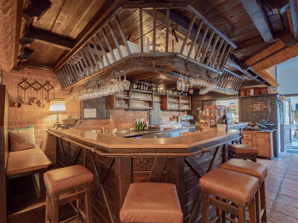 a large kitchen with a large bar with stools at Hotel Johannes-Zeche in Illmitz