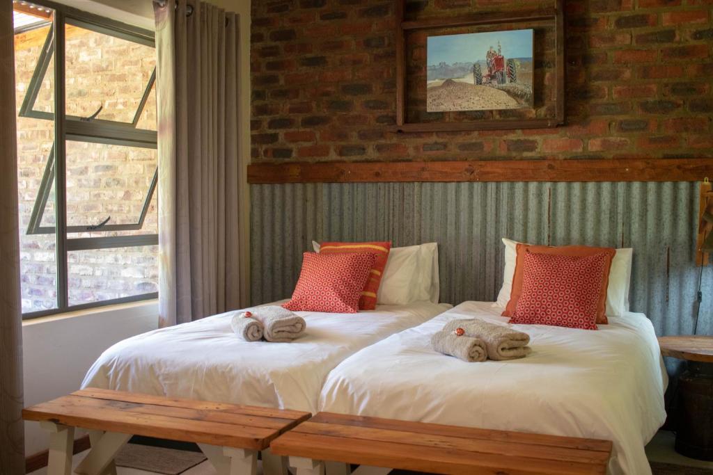 een slaapkamer met 2 bedden en handdoeken bij Anderland - De Oude Melkstal in Potchefstroom